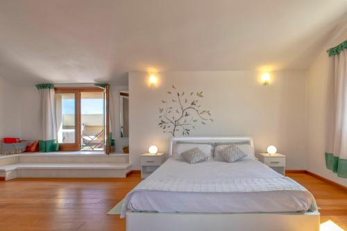 een slaapkamer met een wit bed en een raam bij Sardinia Guest House in Olmedo