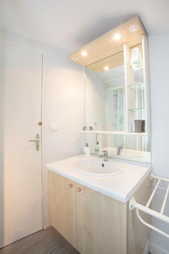 une salle de bain blanche avec un lavabo et un miroir dans l'établissement Logis historique au centre de Périgueux 8 lits L Oustal, à Périgueux