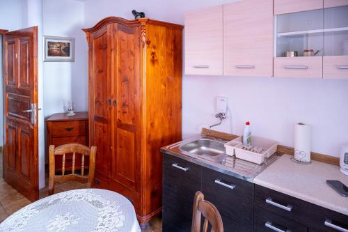 a kitchen with a sink and a wooden cabinet at 2- posteľová izba s kúpeľňou a kuchynkou RIŠKO v PENZION TRSTENÁ in Trstená