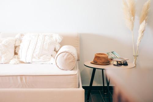 a white bed with a hat and a table at Althaia Hotel in Thermo