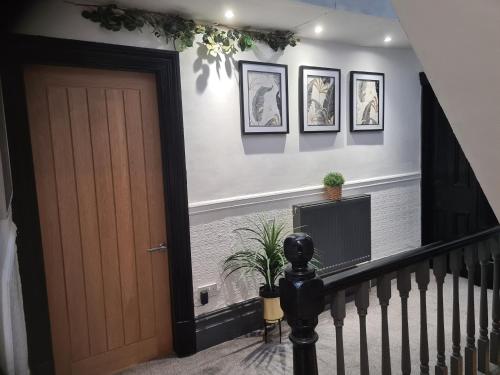 a hallway with a staircase with a door and a tv at Albert Rd Aparthotel in Colne