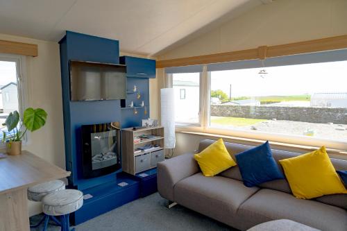 a living room with a couch and a blue wall at Kittiwake in Saint Cyrus