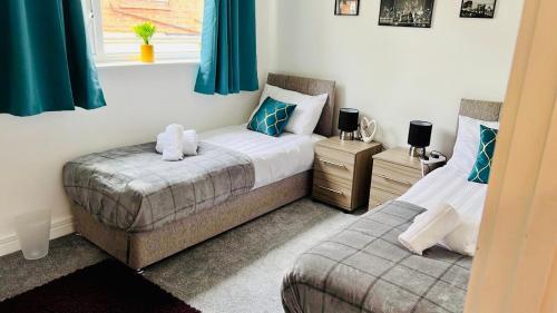 a bedroom with two beds and a window at Spacious and Bright 2 Bedroom Apartment, Sleeps 6, 1st Floor with Free Parking, Business and Leisure by Jesswood Properties in Hinckley