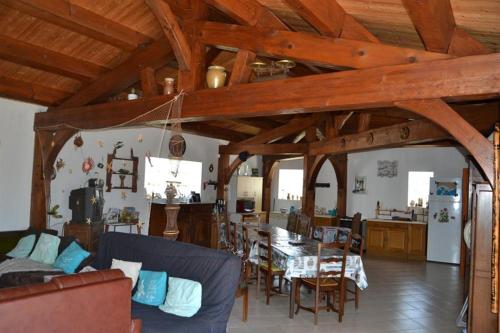 un salon avec un canapé bleu et une table dans l'établissement NOIRMOUTIER : LOCATION DE VACANCES POUR 8 PERSONNES À BARBÂTRE, à Barbâtre