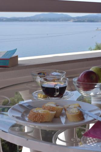 a plate of food on a glass table with food at Baracunda Apartments in Barbati