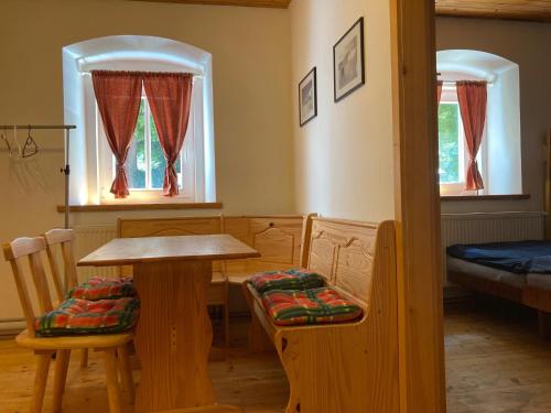 Cette chambre comprend une table, des chaises et un lit. dans l'établissement Vila Adélka - útulná chalupa v Krkonoších, à Horní Maršov