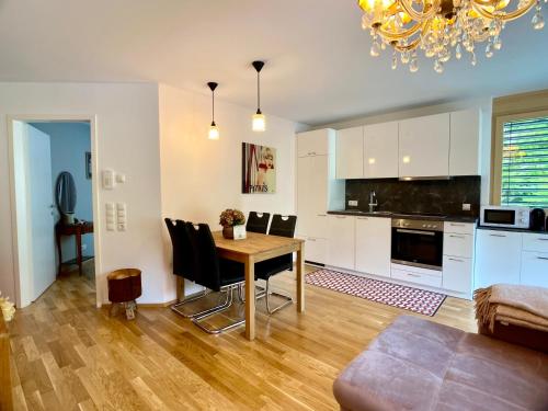 uma cozinha e sala de jantar com mesa e cadeiras em Stilvolles Apartment «Coco» am Bodensee em Hörbranz