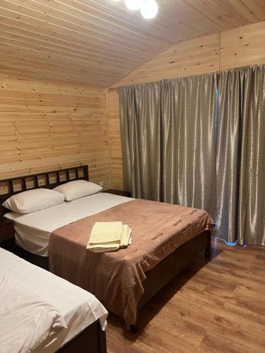 1 dormitorio con 2 camas en una cabaña de madera en Guest house Adel, en Novi Afon