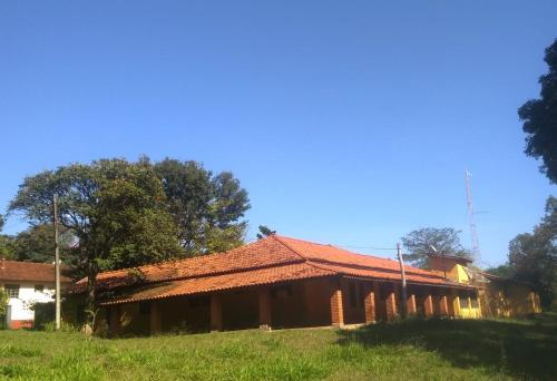 a house with a red roof in a field at Casa de sitio em Brotas in Brotas