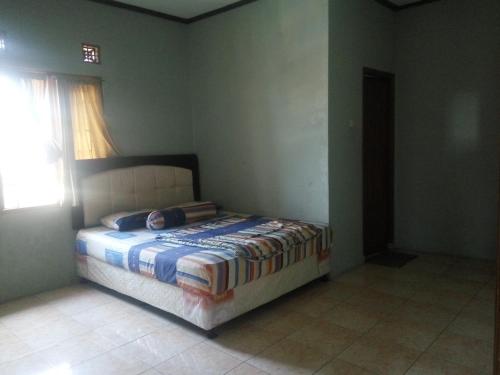 um quarto com uma cama num quarto com uma janela em Villa bhifa Puncak em Bogor