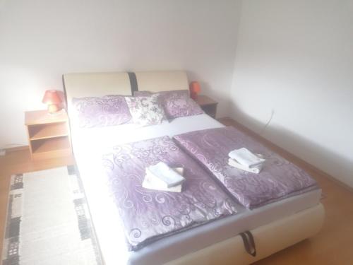 - un lit avec des draps et des oreillers violets dans l'établissement Apartment Jopa, à Korenica