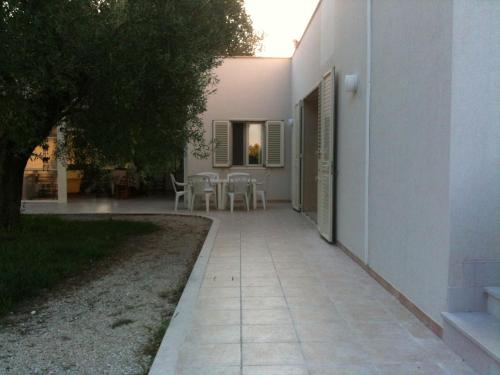 a walkway outside of a house with a table and chairs at B&B Finestre Tra Gli Ulivi in Mesagne