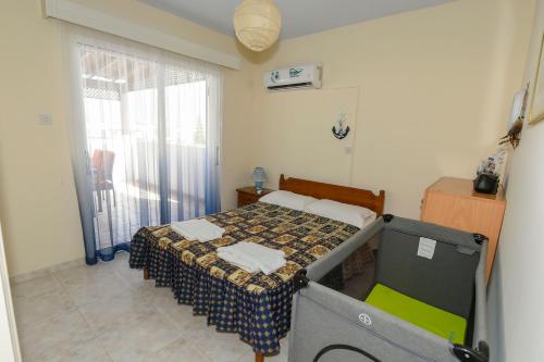 a small bedroom with a bed and a window at The Blue Mile in Paralimni