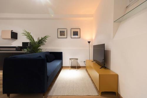 a living room with a blue couch and a tv at Studio Rivoli Loft in Milan