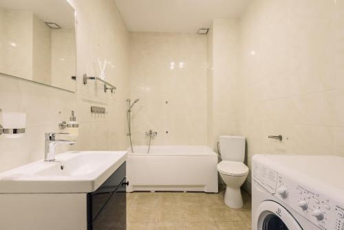 ein weißes Badezimmer mit einer Badewanne, einem Waschbecken und einem WC in der Unterkunft Apartament Gdańska nad Jeziorakiem Iława in Iława