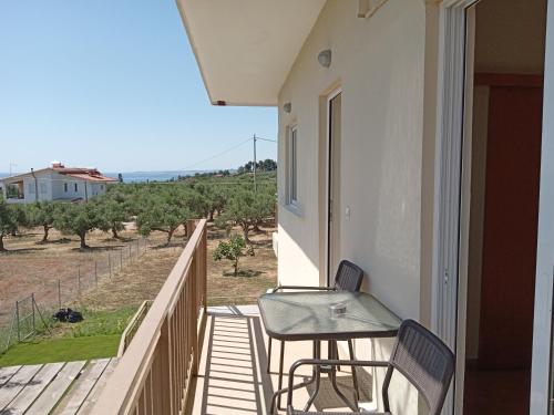 a balcony with a table and chairs and a view at Nereids Apartments-Agavi in Petalidi