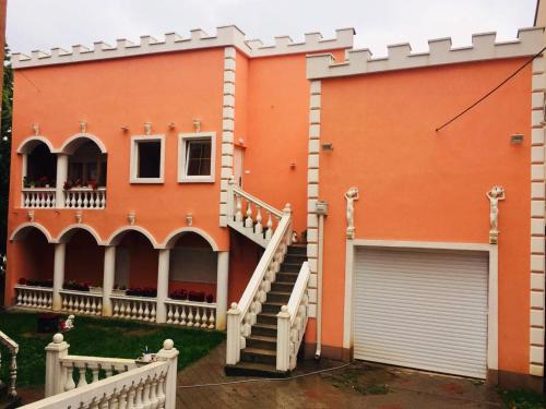 een oranje huis met een trap en een garage bij Aprtmani "M" br4 in Topola