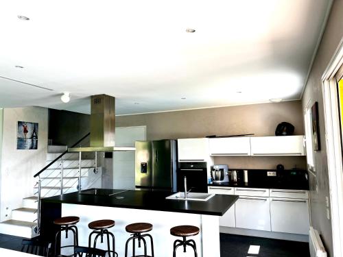 a kitchen with a black counter and stools in it at Villa Les Anges in Saint-Andre-de-la-Roche