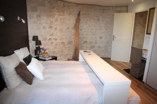 a bedroom with a large white bed with a desk at Gîte Lorengrain in Bruyères-et-Montbérault