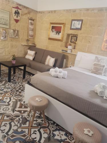 a bedroom with a large bed and a couch at Le camelie in Altamura