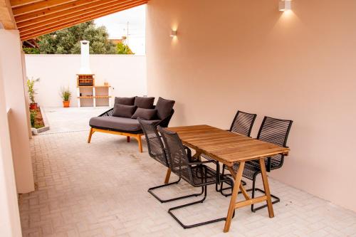 un patio con mesa de madera, sillas y sofá en Palmira's - relaxing countryside house in Batalha, en Batalha