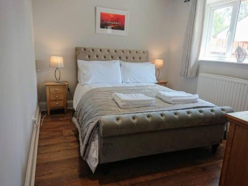 En eller flere senge i et værelse på Riverside Cottage 6 guests 4 adults max hot tub