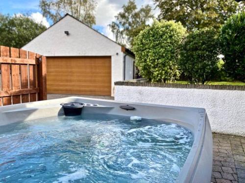 a hot tub in a backyard with a fence at Riverside Cottage 6 guests 4 adults max hot tub in Backbarrow