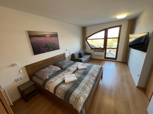 a bedroom with a bed and a large window at OPILÝ SKLEP in Velké Pavlovice