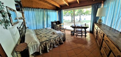 una camera con un letto, un tavolo e una finestra di VILLA CECILIA sul LAGO fronte MARE a Sperlonga