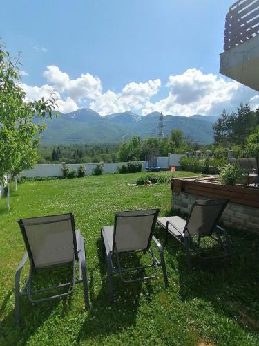 two chairs sitting in the grass in a yard at Къща за гости Радост Guest House Radost in Razlog