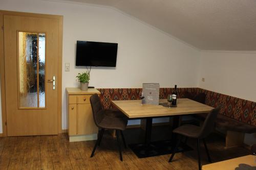 a room with a table and a couch and a television at Sportpension Rubin in Sölden