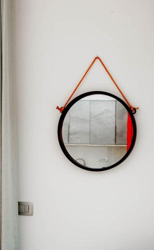a mirror hanging on a wall next to a curtain at Natura Luxury Suites Parga in Parga
