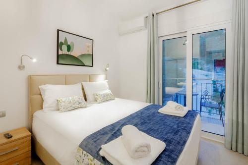 a bedroom with a bed with two towels on it at Natura Luxury Suites Parga in Parga