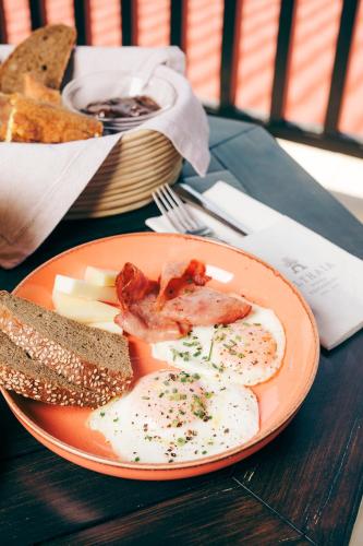 a plate of food with eggs and bread on a table at Althaia Hotel in Thermo