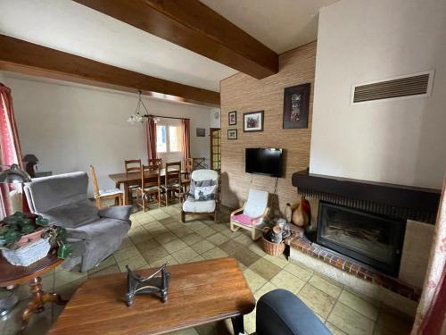 Maison chaleureuse au coeur des Aspres في Camélas: غرفة معيشة مع موقد وغرفة طعام