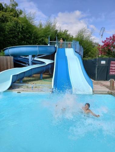 - un garçon qui nage sur un toboggan aquatique dans une piscine dans l'établissement Mobil Home 