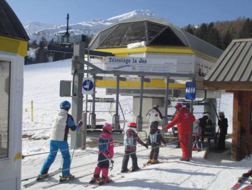 a group of people on skis at a ski lift at Vue panoramique tout confort 150m pistes commerces et loisirs in Superdevoluy