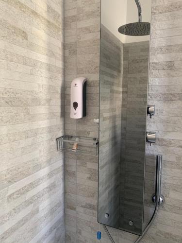 a shower with a glass door and a soap dispenser at B&B IV Vico in Miglianico
