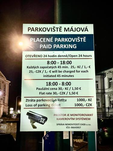 a parking sign on a pole next to a parking meter at Pension Májovka in Cheb