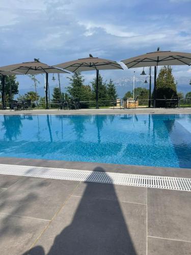 a swimming pool with umbrellas on top of it at Toka Hotel Restaurant in Pogradec