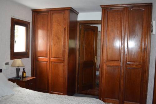 a bedroom with wooden cabinets next to a bed at Divina casa en Carrasco con piscina y pool in Montevideo