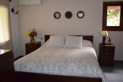 a bedroom with a bed with two night stands and a window at Divina casa en Carrasco con piscina y pool in Montevideo