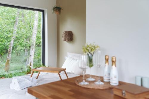 een kamer met een bed, een tafel en een raam bij River Cabin in Inciems