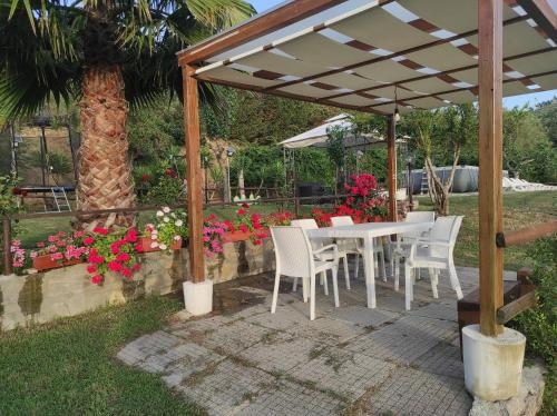 a white table and chairs under a wooden pergola at Zefiro Casa Vacanze in Ascea