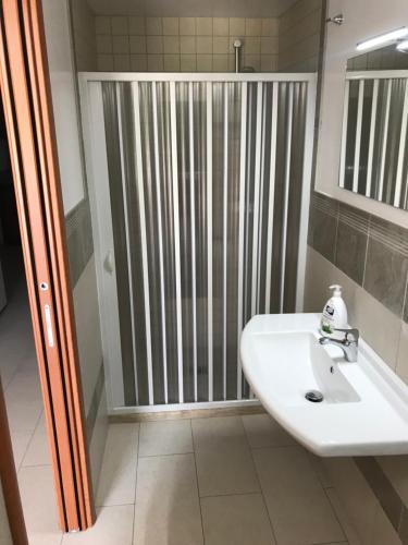 een badkamer met een douche en een witte wastafel bij Vacanze Fuori Porta in Grottaglie