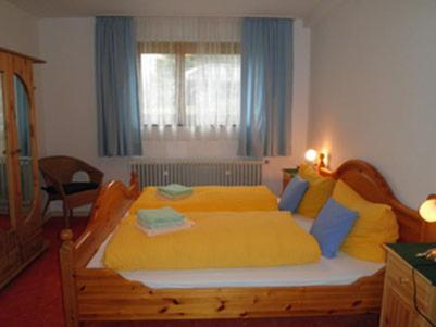 um quarto com uma cama grande com lençóis amarelos em Ferienhäusle Sonnenblume Titisee em Titisee-Neustadt