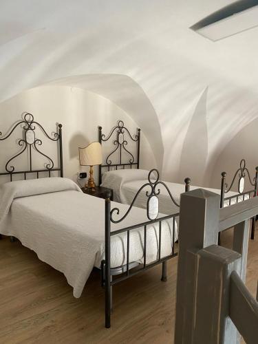 una camera con due letti e un soffitto bianco di SUITE76 a Torre Santa Susanna