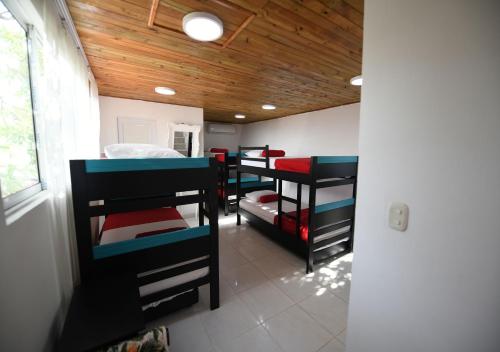 a room with four bunk beds in a room with a ceiling at Imagine Beach in Puerto Colombia