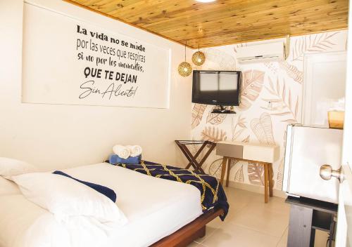 1 dormitorio con 1 cama y TV en la pared en Imagine Beach, en Puerto Colombia