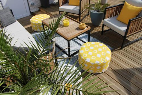 une terrasse avec des chaises, une table et une plante dans l'établissement "Chez Lyly et Juju" Piscine&Calme 3Chambres, à Angers